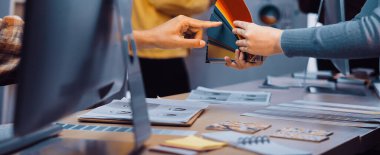 Modern ofis ortamında renkli palet seçimi sergileyen bir tasarımcı ve bir müşteri arasındaki dinamik bir değişim. Yaratıcılık bu ortak alanda gelişiyor. SACTR