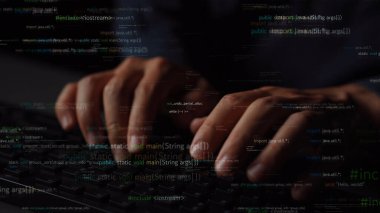 Teknoloji ve yazılım gelişiminin özünü modern bir çalışma alanında yansıtan katmanlı programlama koduyla çevrili bir klavyeye özenle yazı yazan ellerin yakın plan görüntüsü. Xenic