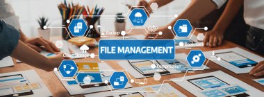 Bu resim, verimli iş süreçleri için çeşitli dijital araçlar ve teknolojik arayüzlerin yer aldığı, dosya yönetimi tekniklerine odaklanmış işbirlikçi bir çalışma alanını gösteriyor. Dostluk