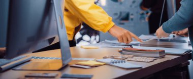 Canlı bir çalışma alanı, işbirlikçi tasarım faaliyetlerine katılan profesyonelleri gösteriyor. Renkli örnekler ve malzemeler, yaratıcılığı ön plana çıkaran şık bir masa boyunca yayılıyor. SACTR