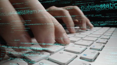 Bu yakın plan resim, modern bir çalışma ortamında teknoloji ve programlama uzmanlığının kesişimini gösteren dijital kod elemanlarıyla çevrili bir klavyede yazı yazan elleri gösteriyor. Xenic