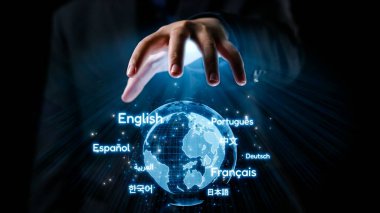 Çeşitli dilleri gösteren bir kürenin dijital temsiline uzanan bir elin yakın çekimi. Bu küresel iletişimi ve kültürel çeşitliliği sembolize eder. Dörtgen