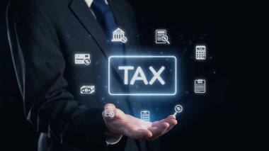 A businessman in a suit is presenting a holographic display of tax-related icons, capturing themes of finance, accounting, and taxation on a dark background. Qubit