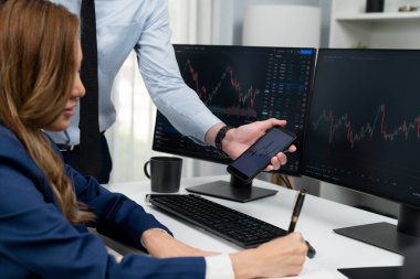 Kâr değeri değeri oranı online web sitesi uygulamasını ev ofisinde analiz etmek için notlar yazan kadınlara telefonda dinamik borsa verilerini gösteren bir işadamı eli kesilmiş. İnfobahn.