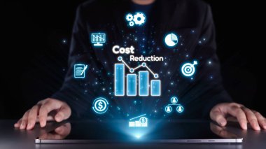 Bir işadamı dizüstü bilgisayarın önünde oturmuş, maliyet azaltma, finans stratejileri ve işyerindeki dijital yenilikleri temsil eden parlak simgeler ve grafiklerle uğraşıyor. Dörtgen