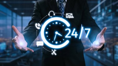 Bir işadamı, lüks bir ofis ortamında modern iş desteğini gösteren dijital saat grafikleri ve iletişim simgeleri kullanarak 24 saat kullanılabilirlik sergiliyor. Dörtgen