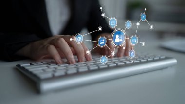 Çevrimiçi iletişimi ve ağ oluşturmayı sembolize eden, modern teknoloji ve işbirliğini vurgulayan dijital simgelerle birlikte bir klavyede yazı yazan profesyonel bir ayar. Tessel