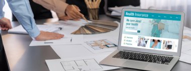 İç mimar tasarımcı grubu, daha kesin tasarım için planlar ve dizüstü bilgisayar ekran mimari yazılımı üzerinde birlikte tartışıyorlar. Modern ev tasarımı ve yenileme. İçgörü