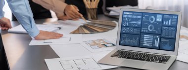 İç mimar tasarımcı grubu, daha kesin tasarım için planlar ve dizüstü bilgisayar ekran mimari yazılımı üzerinde birlikte tartışıyorlar. Modern ev tasarımı ve yenileme. İçgörü