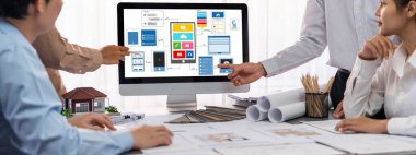 İç mimar tasarımcı grubu, daha kesin tasarım için planlar ve dizüstü bilgisayar ekran mimari yazılımı üzerinde birlikte tartışıyorlar. Modern ev tasarımı ve yenileme. İçgörü