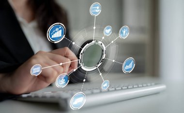 Profesyonel bir kadın, modern bir iş ortamında veri analizi ve bağlantıyı sembolize eden dijital simgelerle çevrili bir dizüstü bilgisayarla etkileşime girer. Crux