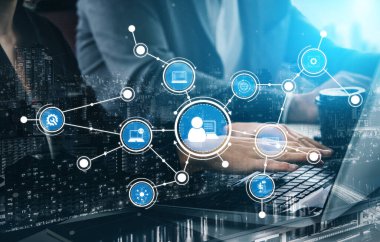 Bir profesyonel, dijital ağ bağlantıları ve verimli veri yönetimi ve işbirliği teknolojisinin sergilendiği modern bir çalışma alanında dizüstü bilgisayarla etkileşime girer. Tessel