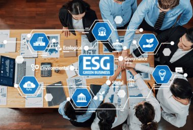 Dinamik bir ofis sahnesi, yeşil iş stratejilerine odaklanmış takım çalışması. Bu resim ESG ilkelerinin önemini ve sürdürülebilir bir gelecek için işbirlikçi çabaların önemini vurgular. Dostluk