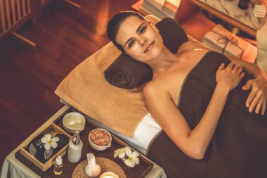 Beyaz kadın müşteri stres önleyici spa masajının keyfini çıkarıyor ve lüks otel ya da otelde sıcak mum ışığında güzellik teniyle eğleniyor. Sessiz.