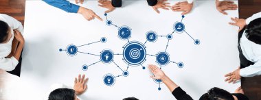 Proje sonuçlarını ve ticari başarıyı geliştirmek için bilgi grafikleri ve görselleştirme araçlarıyla strateji oluşturan çeşitli profesyoneller bir masa etrafında işbirliği yapar. Dostluk