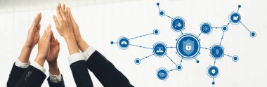Siber güvenlikteki takım çalışmasının dinamik bir temsili dijital koruma ikonlarından oluşan bir ağa uzanan eller, modern bir iş ortamında işbirliği ve güveni sembolize ediyor. Dostluk