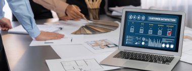 İç mimar tasarımcı grubu, daha kesin tasarım için planlar ve dizüstü bilgisayar ekran mimari yazılımı üzerinde birlikte tartışıyorlar. Modern ev tasarımı ve yenileme. İçgörü