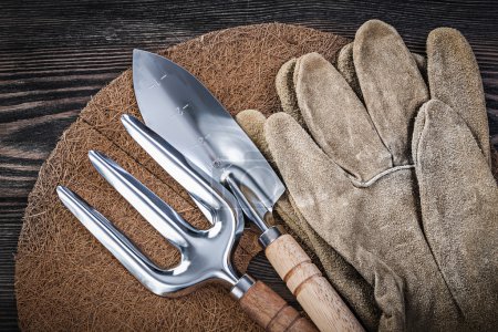 Foto de Mulching fibra mano pala paleta tenedor guantes de seguridad en concepto de jardinería de madera
. - Imagen libre de derechos