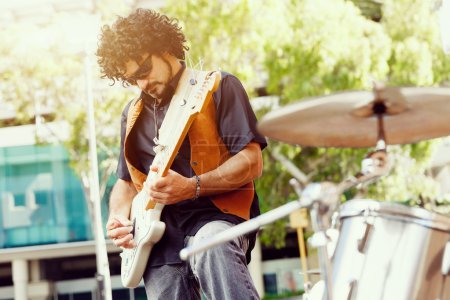 Téléchargez les photos : Un musicien de rue jouant de sa guitare - en image libre de droit