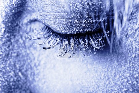Ojo de mujer congelado cubierto de heladas

