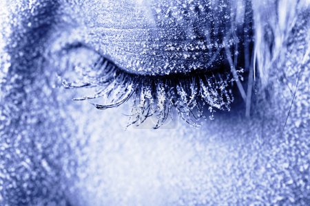 Photo for Frozen woman's eye covered in frost. Close-up shot toned in blue - Royalty Free Image