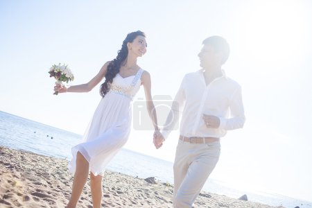 Acabo de casarme feliz pareja corriendo en una playa de arena
Acabo de casarme feliz pareja corriendo en una playa de arena