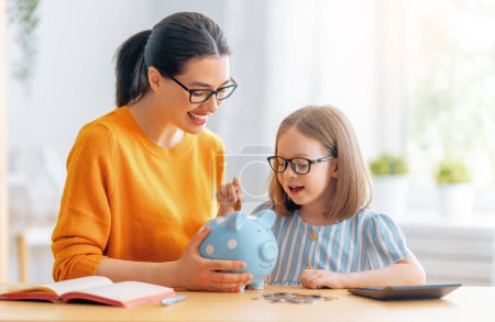 Mujer y niño sentado en el escritorio con una alcancía están calculando los gastos, la gestión del presupuesto familiar.