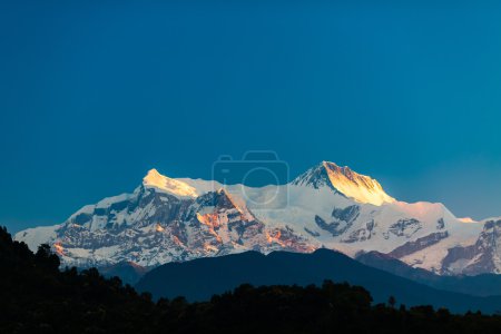 Téléchargez les photos : Montagne magnifique paysage de coucher de soleil inspirant dans les montagnes de l'Himalaya. Himalaya Annapurna IV (7525m) et Annapurna II (7937m) culminent au-dessus du ciel bleu. Vue sur les montagnes paysage de la ville de Pokhara, Népal
. - en image libre de droit