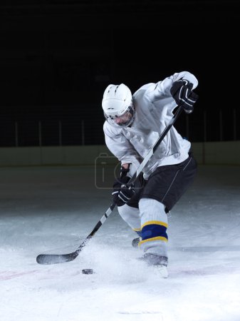 Foto de Jugador de hockey sobre hielo en acción patadas con palo - Imagen libre de derechos