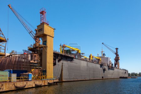 Photo for Dry floating dock and cranes in shipyard. - Royalty Free Image