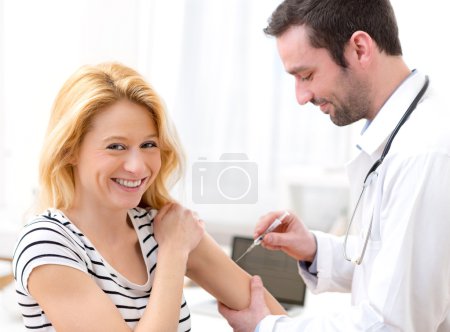 Photo for View of a Young attractive woman being vaccinated - Royalty Free Image