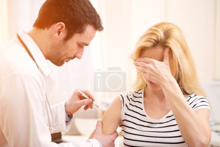 Young attractive woman being vaccinated