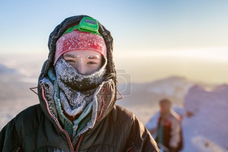 Téléchargez les photos : Frost Portrait d'un randonneur grimpeur. Enveloppé dans un chapeau et une écharpe givré - en image libre de droit