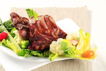 Photo for Smoked pork ribs and vegetable garnish - Royalty Free Image