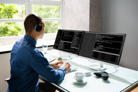 Photo for Computer Programmer Writing Program Code On Computer In Office - Royalty Free Image