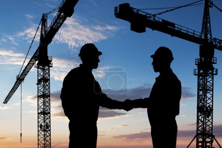 Photo for Silhouette Of Two Architects At Construction Site Shaking Hand - Royalty Free Image