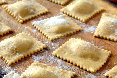 Photo for Raw braised beef agnolotti on wooden table, closeup shot. - Royalty Free Image