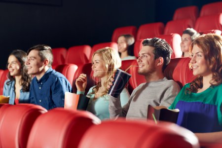 happy friends watching movie in theater