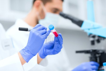 primer plano de las manos de los científicos con tubo de ensayo en laboratorio
