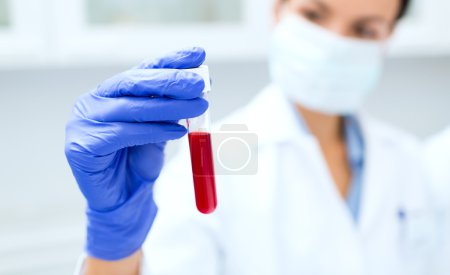 close up of scientist holding test tube in lab