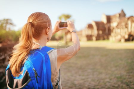 Female tourist taking picture of Angkor Wat temple, Cambodia-stock-photo