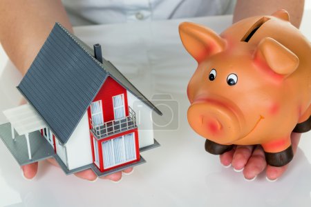 woman with house and piggy bank