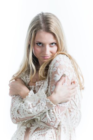 Hermosa chica rubia rusa sobre un fondo blanco en una blusa blanca translúcida
