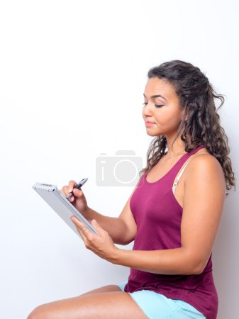 Photo for College age student holding clipboard taking notes concept - Royalty Free Image