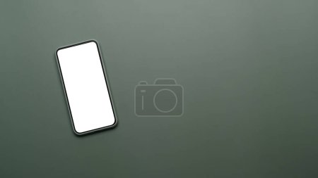 Vista superior de la maqueta de teléfono inteligente con pantalla blanca sobre fondo verde oscuro. Copiar espacio para anunciar texto.