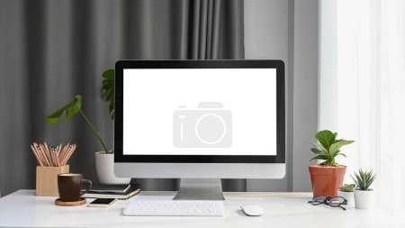 Photo for Front view of mock up computer with blank screen, house plant and office supplies on white office desk. - Royalty Free Image