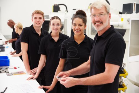 Engineer With Apprentices Checking Components