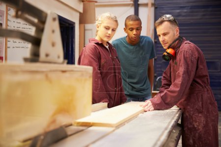 Carpenter With Apprentices Using Circular Saw