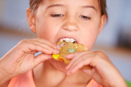 Chica sentada comiendo galletas
