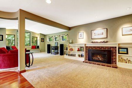 Photo for Living room in light green color with brown soft carpet floor. Fireplace with derocated white shelves - Royalty Free Image